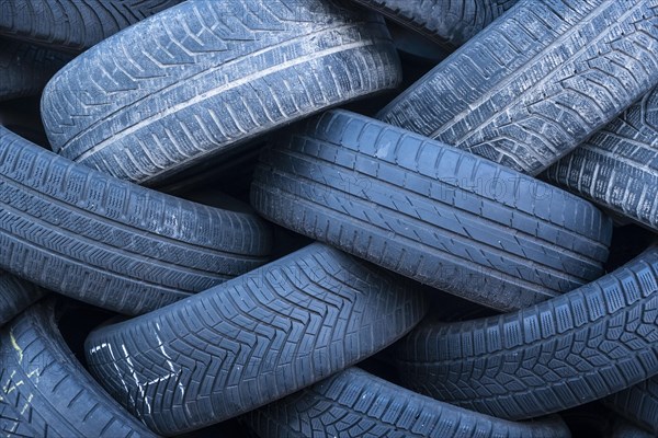 Pile of worn old tyres from passenger cars