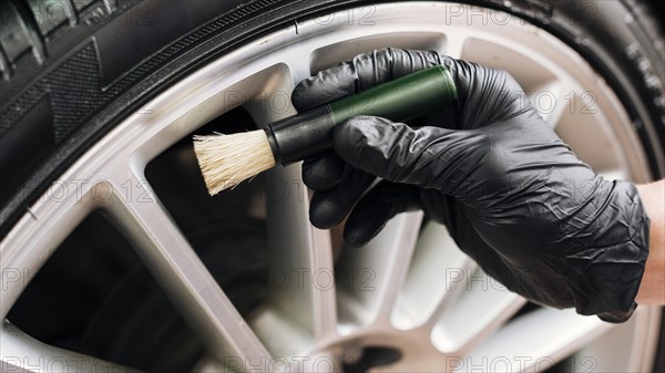 Man cleaning car rims