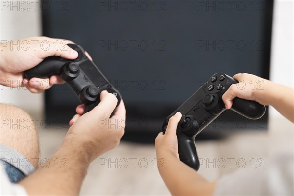 Front view father son playing controllers