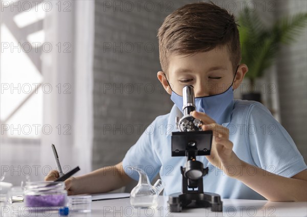 Medium shot kid looking through microscope