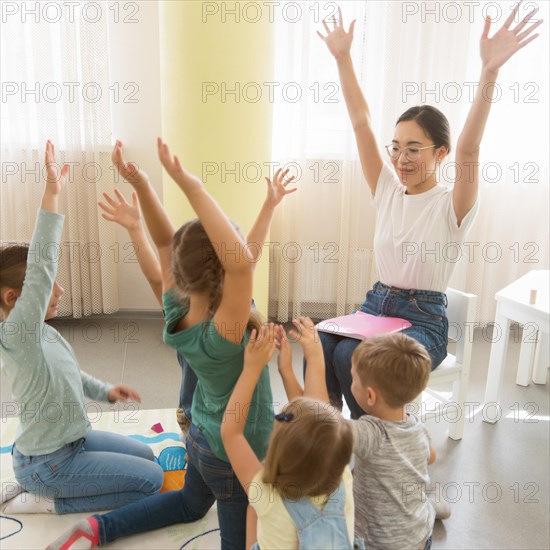 Students playing game their kindergarten teacher