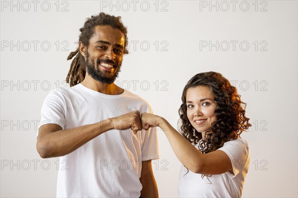 Different racial people fist bumping