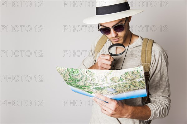 Hipster man with map magnifying glass