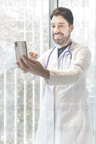 Latino doctor having video conference with his phone