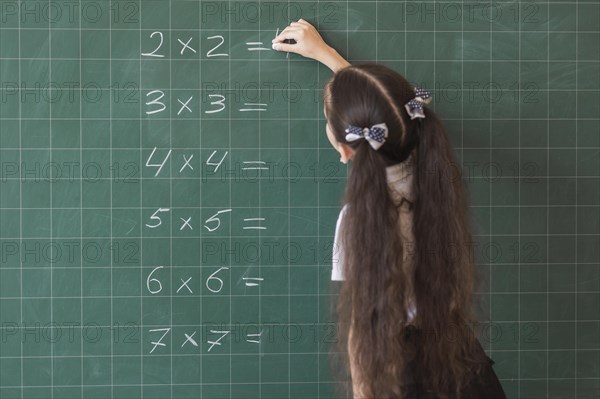 Girl making calculations blackboard