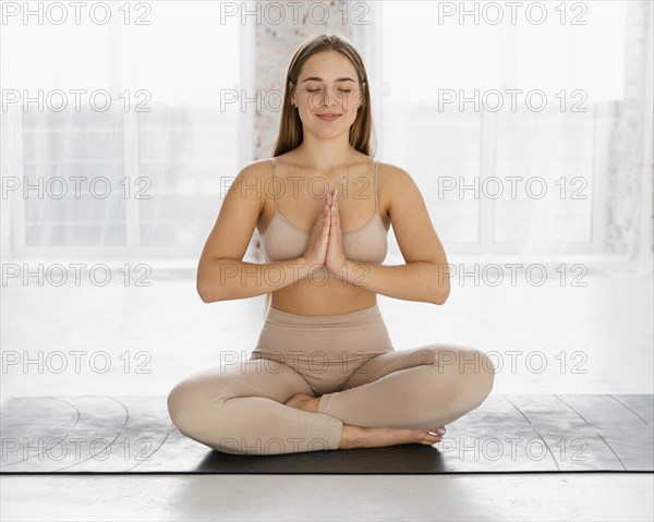 Full shot woman meditating mat