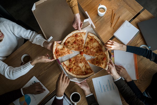 Top view colleagues having pizza during office meeting break