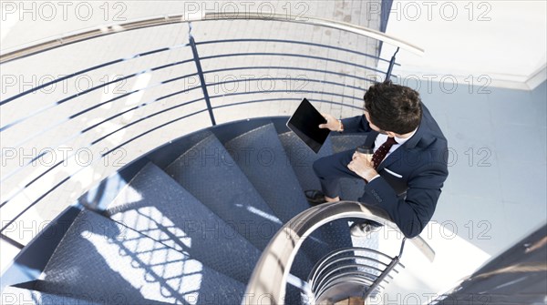 Top view man with tablet standing stairs