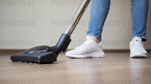 Close up individual using vacuum cleaner