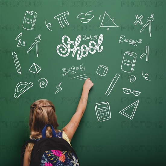 Medium shot girl writing green board