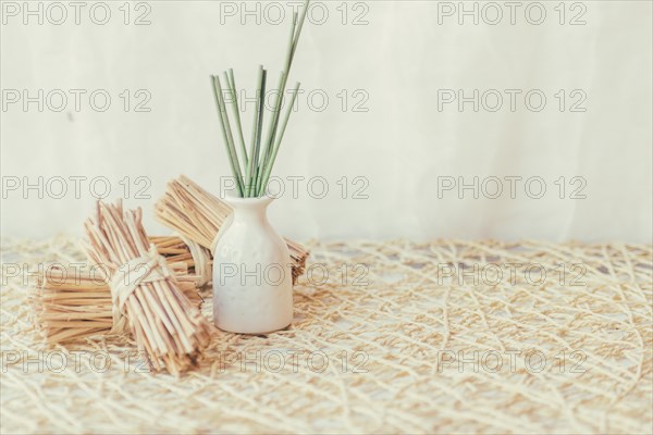 Vase with sticks near bunches sticks