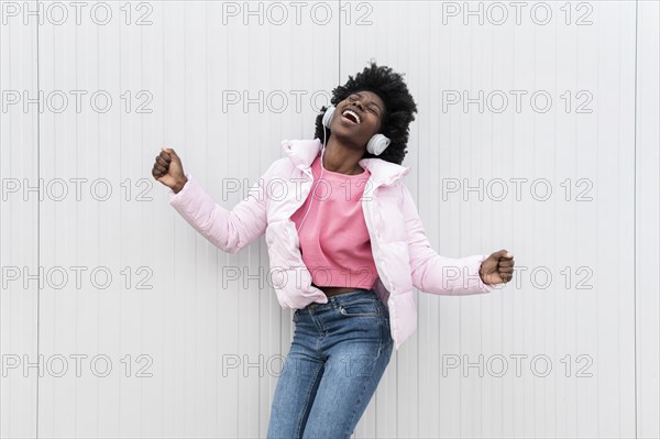 Portrait young woman with headphones jumping