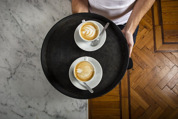 Two cups coffee with latte art tray