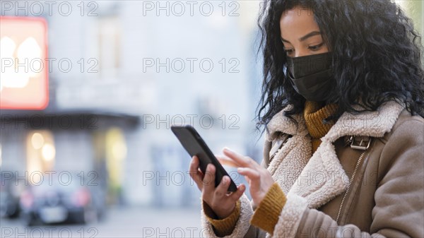 Woman with medical mask checking her phone