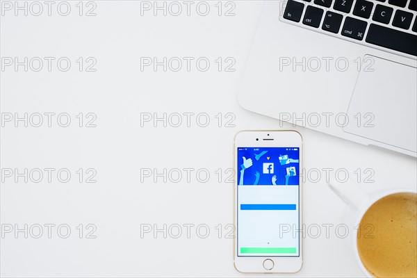 Facebook app phone with coffee laptop