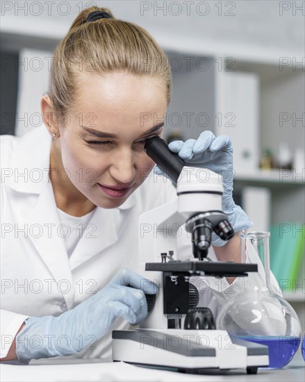 Front view female researcher laboratory with microscope