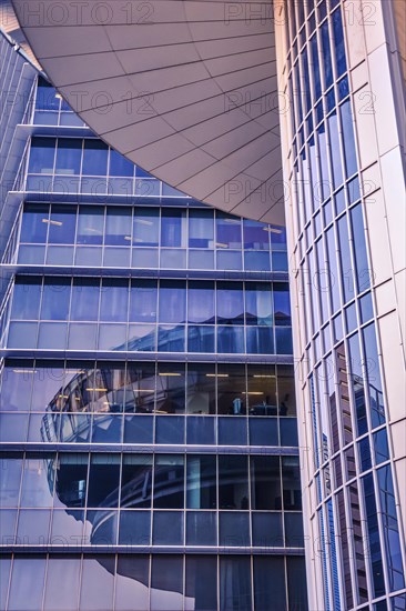 Details. One skyscraper mirroring in the other. Conceptual and artistic image in blue and magenta colors. Geometry of highrise buildings