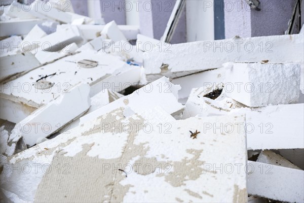 Insulation boards are removed from a facade of a house