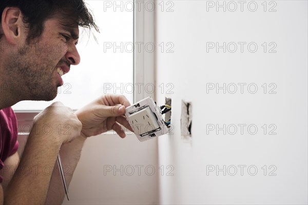 Close up male electrician working home