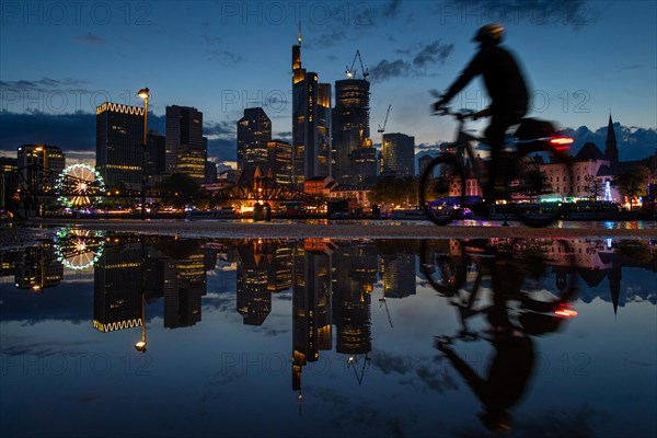 The colourful lights of the Mainfest are reflected in a puddle. The Mainfest on the Mainkai