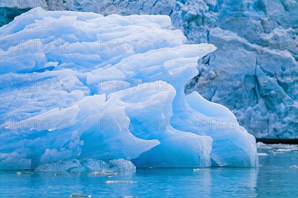 Iceberg floating in the water by a glacier in arctic