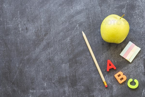 Blackboard with stationery alphabet letters apple