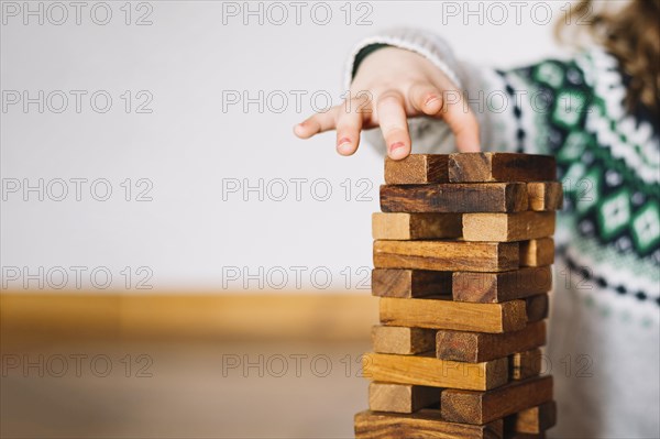 Girl s hand stacking wooden blocks