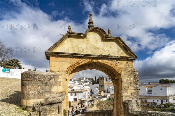 Archway Arco Felipe V and the white houses of the old town with the church Iglesia de Padre Jesus