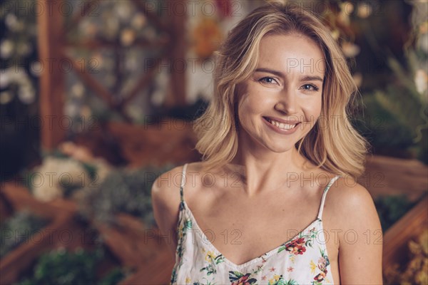 Close up smiling blonde young woman florist shop