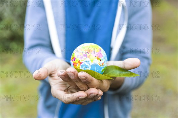 Man holding sphere palm hand with leaf