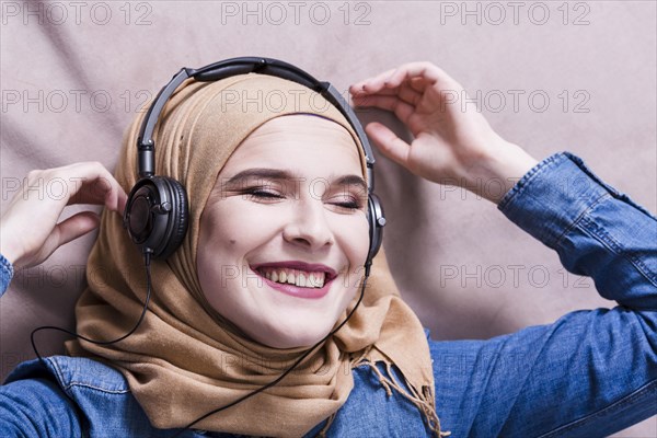 Muslim woman listening music headphones