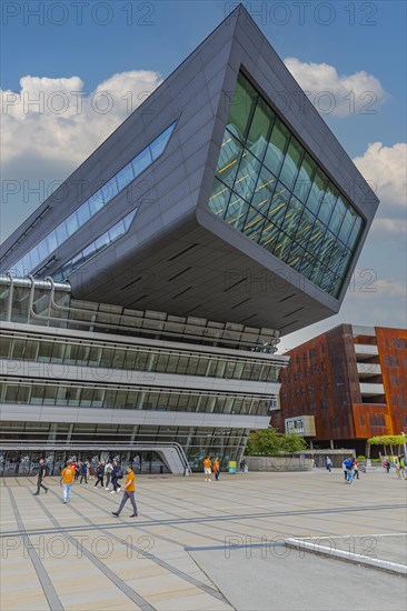 Students in front of modern building on the campus of the University of Economics WU