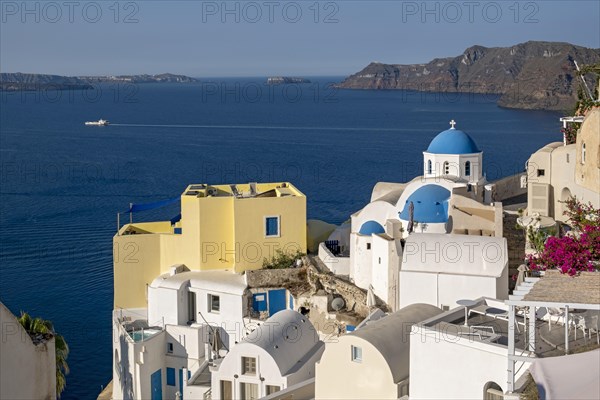 Blue-domed Church of Agios Nikolaos and view of caldera