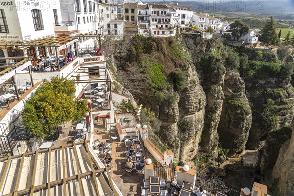 Restaurants high above Tajo de Ronda gorge and the white houses of La Ciudad old town