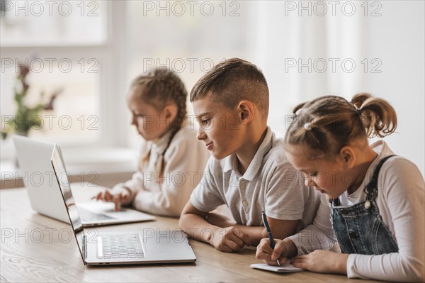 Little kids using laptops school