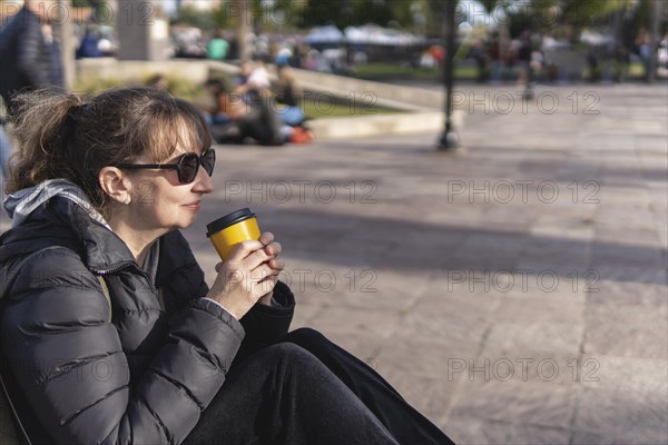 Mature woman sitting on a bench in the street
