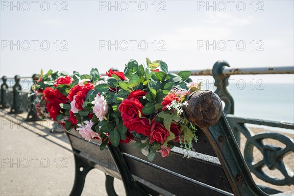 A bench with plastic flowers on the promenade in Brighton