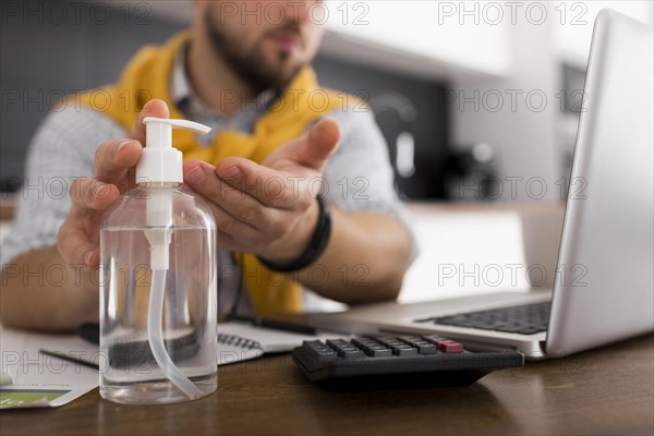 Casual male disinfecting hands