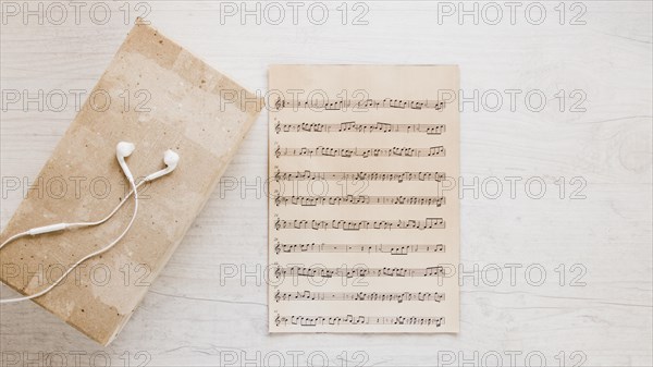 Earphones near old sheet music