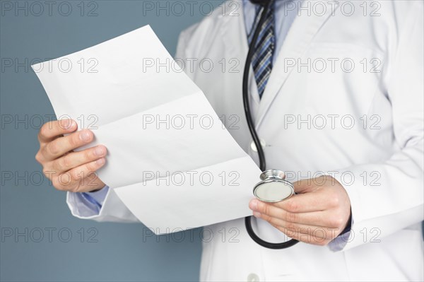 Close up doctor with stethoscope holding medical report hand