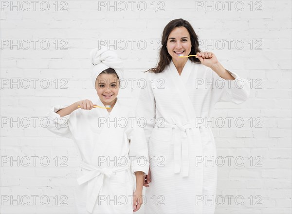 Mother daughter brushing their teeth