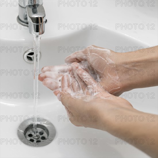 High angle person washing hands sink