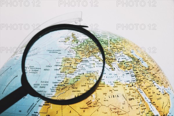 Magnifying glass near globe