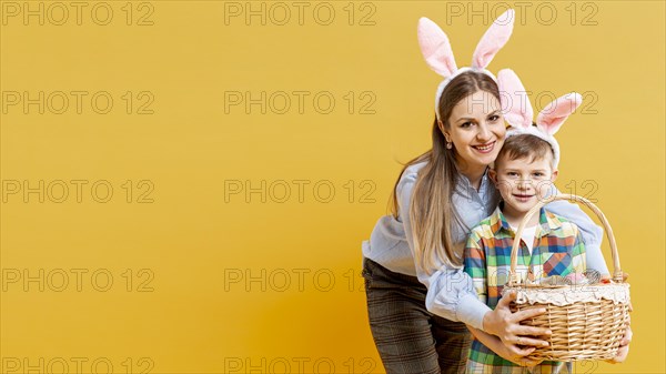 Copy space mother son with basket painted eggs