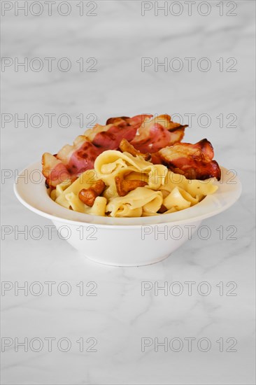 Mushroom pasta with chanterelle and bacon on a plate