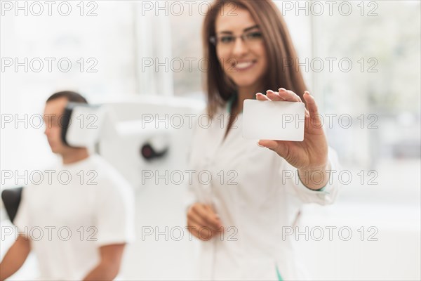 Beautiful female doctor showing card mock up