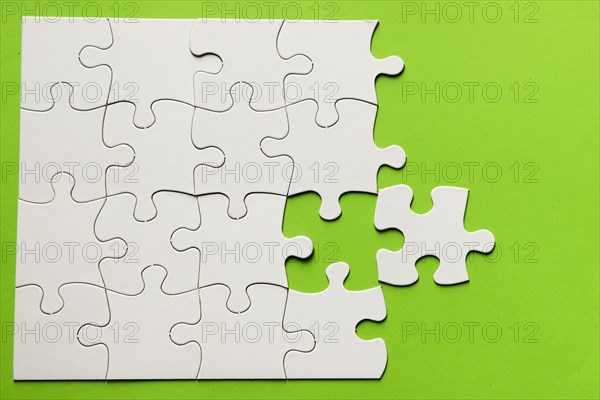 Elevated view cardboard puzzle green background