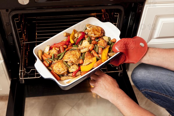 Tray food being put into oven cook