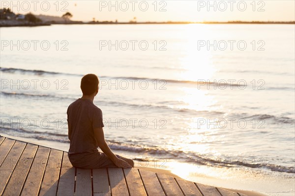 Man meditating beach