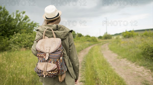 Back view traveller hat walking outdoors